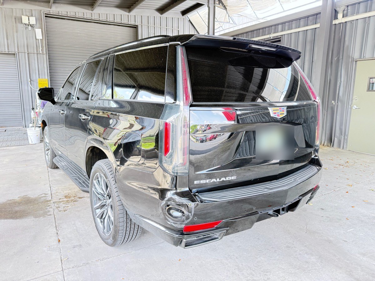 Rear-impact collision damage on a Cadillac Escalade at intake at Collision Center Orlando in Orlando