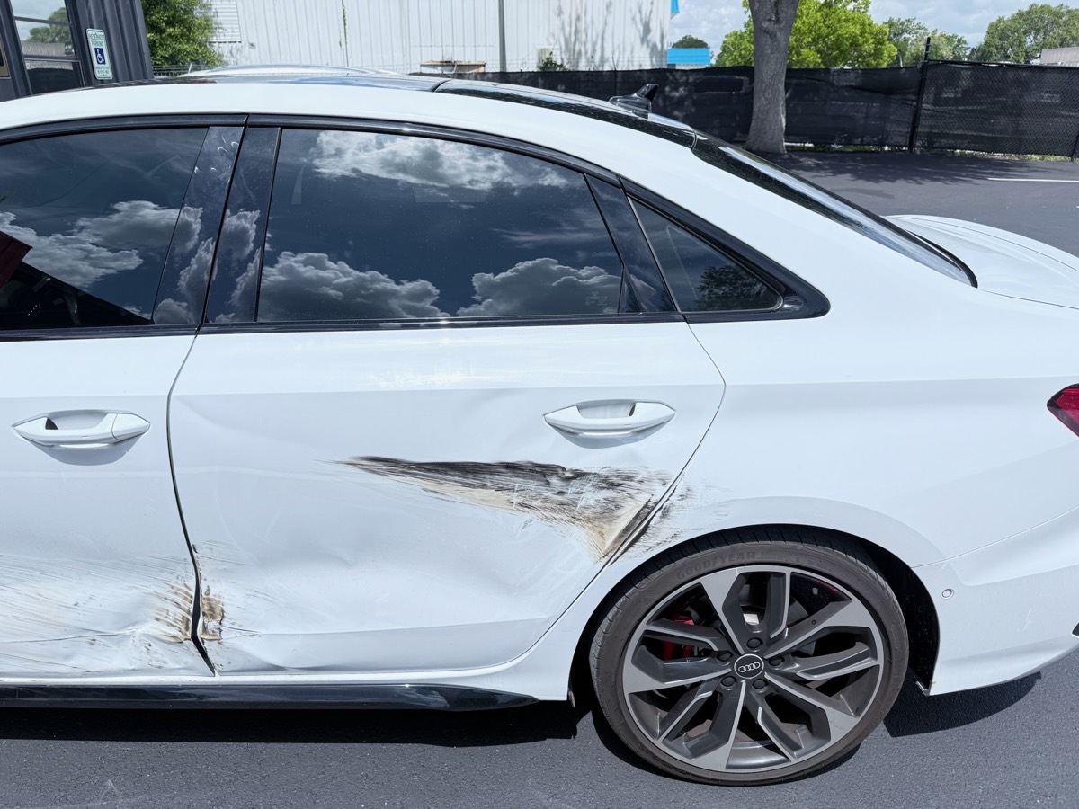 Collision damage on an Audi S3 at intake before repair at Collision Center Orlando