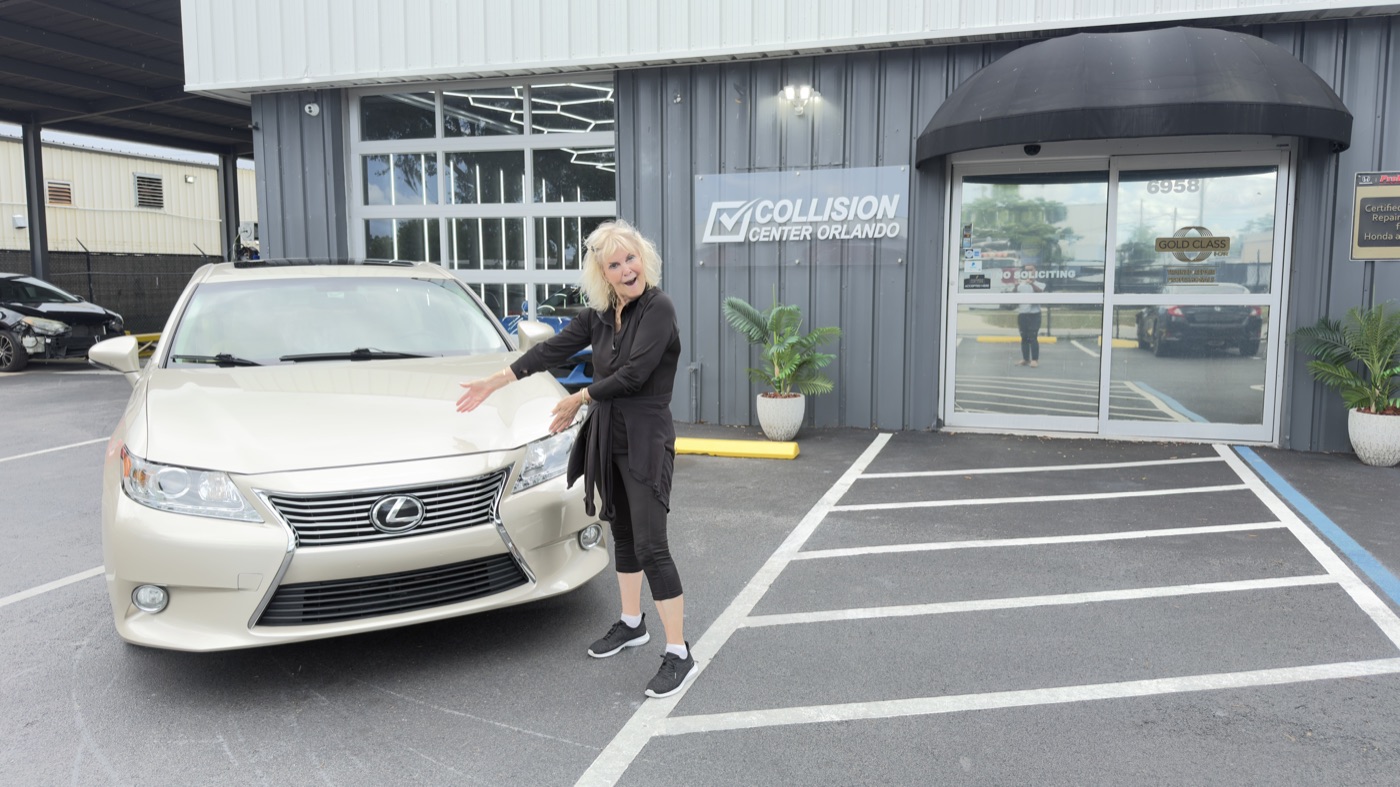 A happy Collision Center Orlando customer at delivery with her finished Lexus after an insurance collision repair