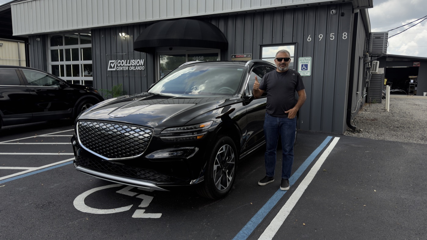 A Collision Center Orlando customer picking up his finished Genesis sedan in Orlando