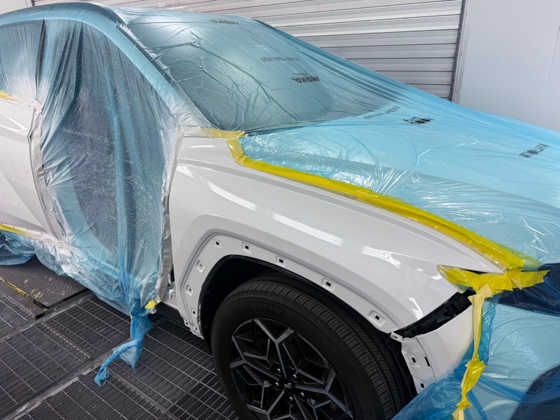 A vehicle masked and prepped in the Collision Center Orlando paint booth for refinishing